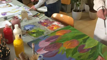 Artists painting on canvases in a studio.