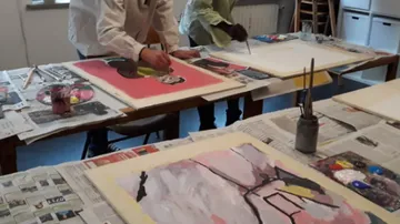 Zwei Personen malen an einem Tisch.