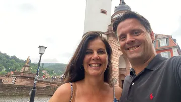 Smiling couple takes selfie at historic city gate.