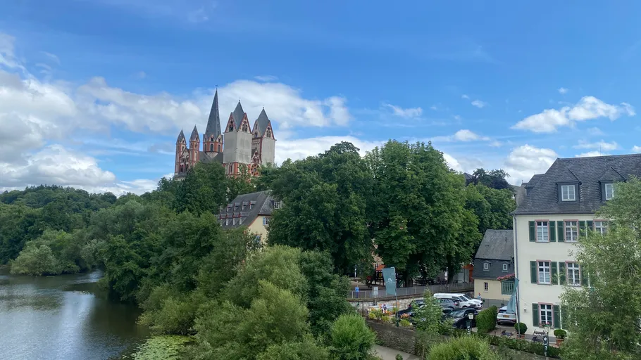 Kathedrale auf Hügel mit Bäumen und Fluss.