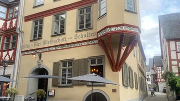 Historic building with umbrellas in courtyard.