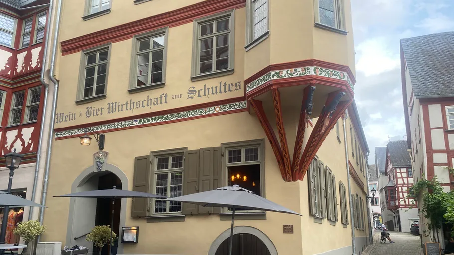 Historic building with umbrellas in courtyard.