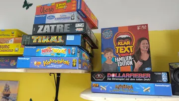 Stapel von Brettspielen auf einem Regal.