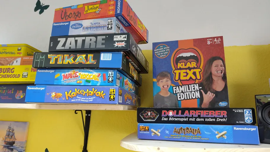 Stapel von Brettspielen auf einem Regal.
