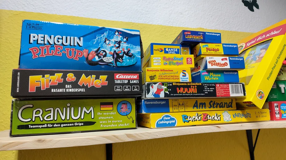 Brettspiele auf einem Regal gestapelt.