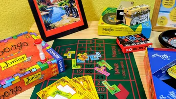Brettspiele und bunte Gegenstände auf Tisch.