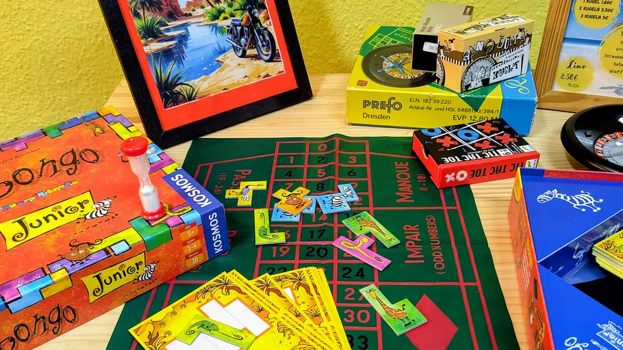 Brettspiele und bunte Gegenstände auf Tisch.