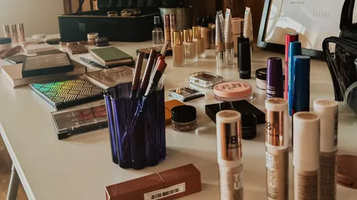 Various makeup products arranged on a white table.