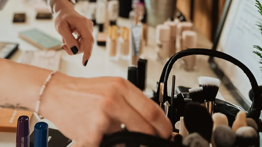 Hände wählen Make-up-Pinsel aus einer Tasche.