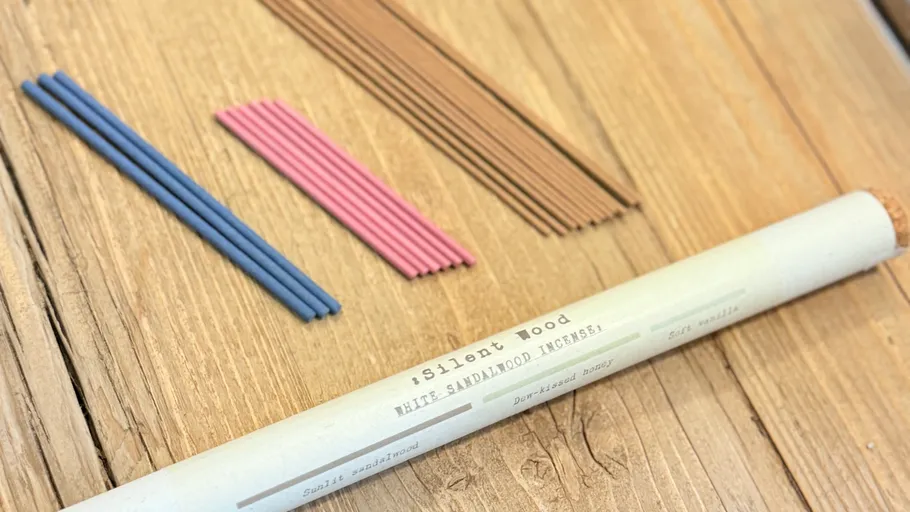 Incense sticks and tube on wooden surface.