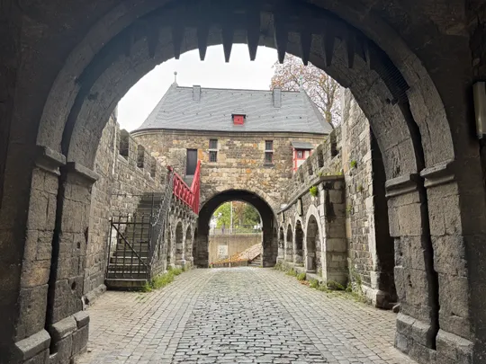 Stone archway leading to historic castle courtyard.