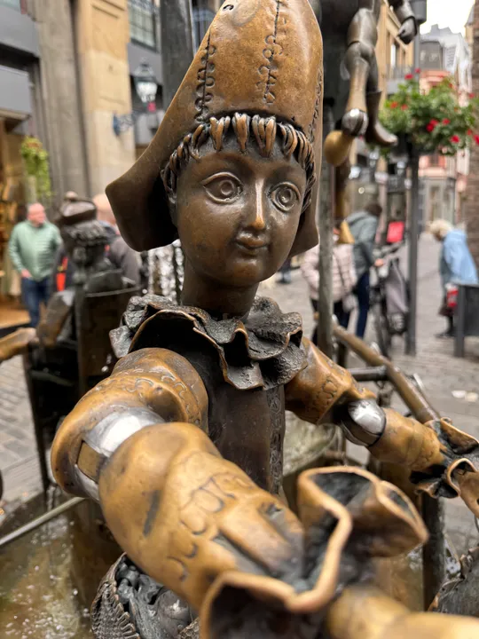 Bronze statue of a child in a city street.