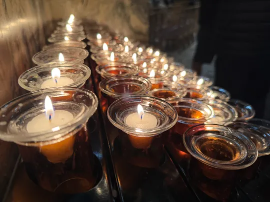 Candles lit in glass holders, dim indoor setting.