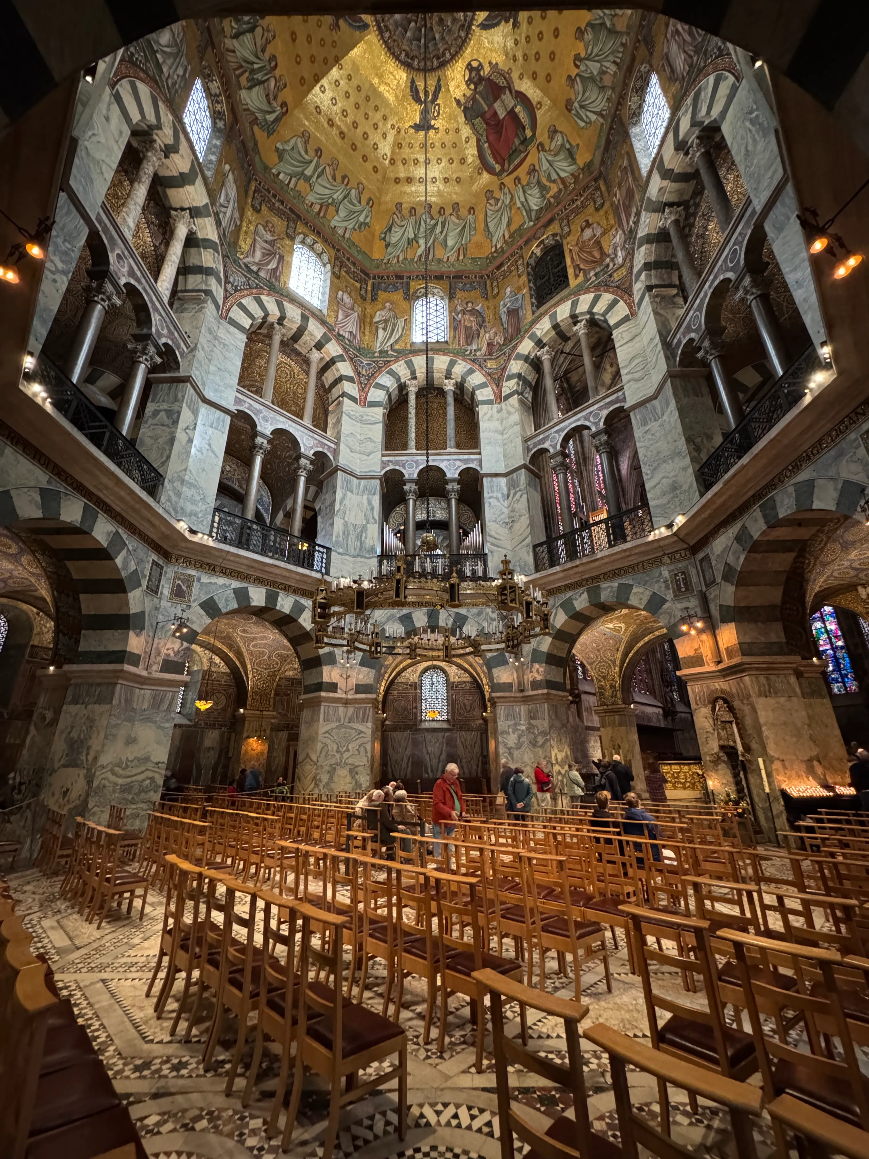 Verzierte Kirchenschiff mit Stühlen und Menschen.