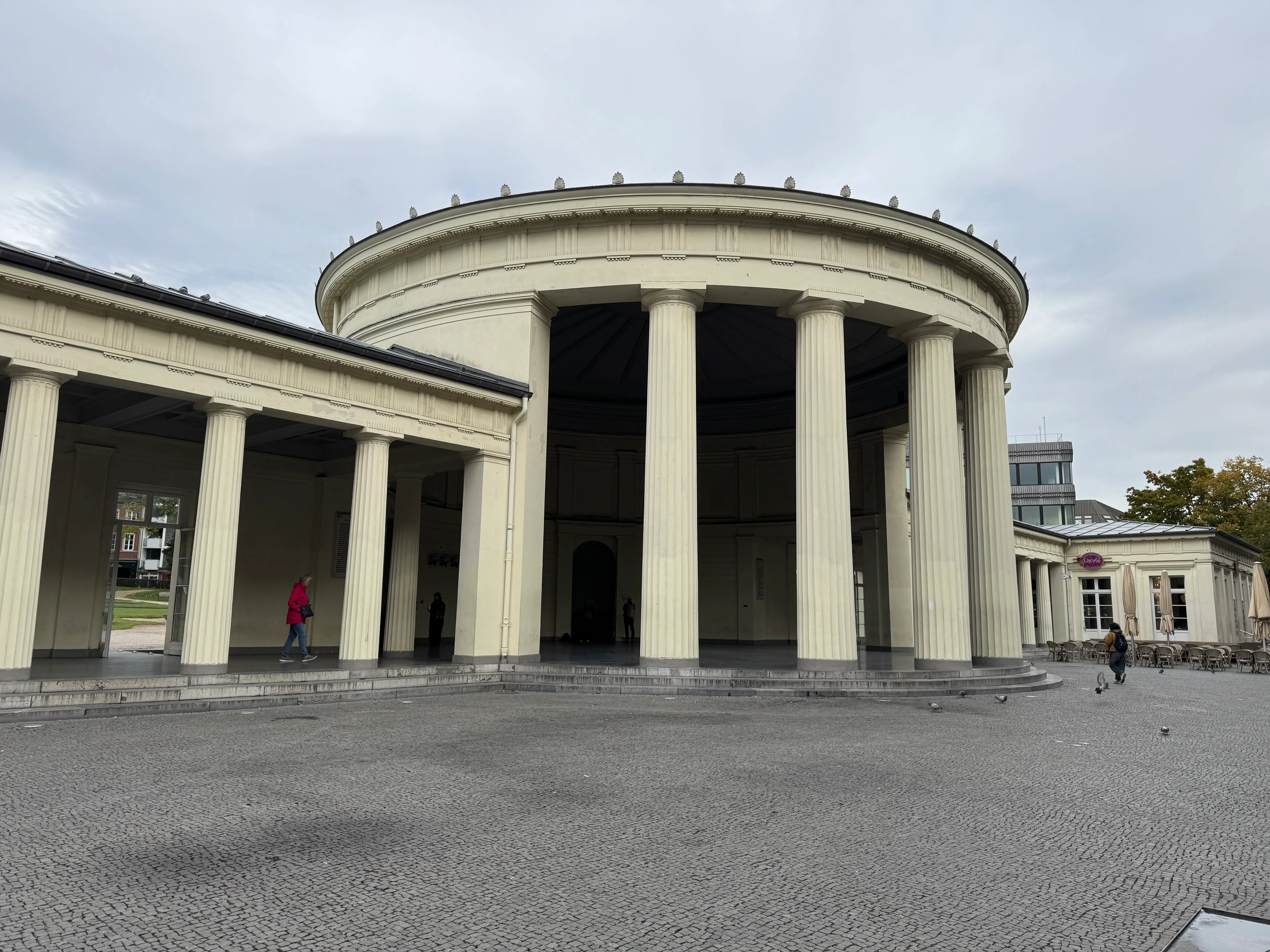 Rundes Gebäude mit Säulen, bewölkter Himmel.