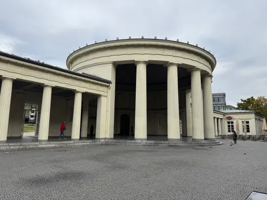 Circular building with columns, overcast sky.