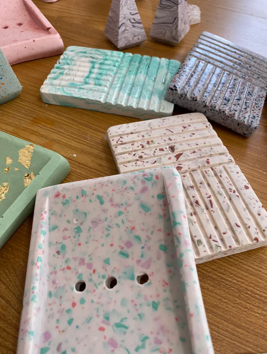Colorful ceramic soap dishes on wooden table.
