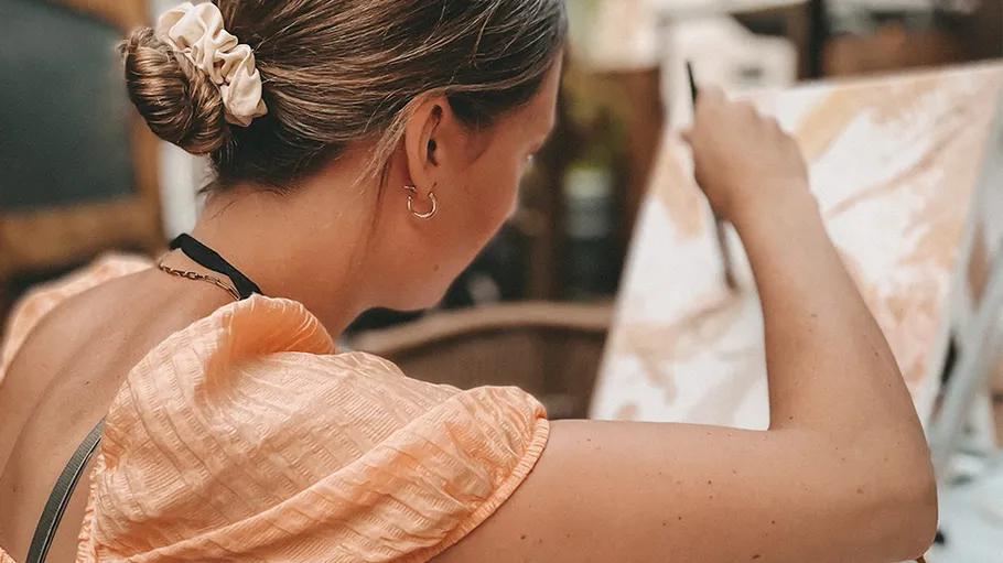 Woman painting a canvas indoors.