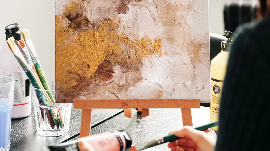 Abstract painting on easel, artist painting in studio.