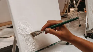 Hand painting textured white canvas.