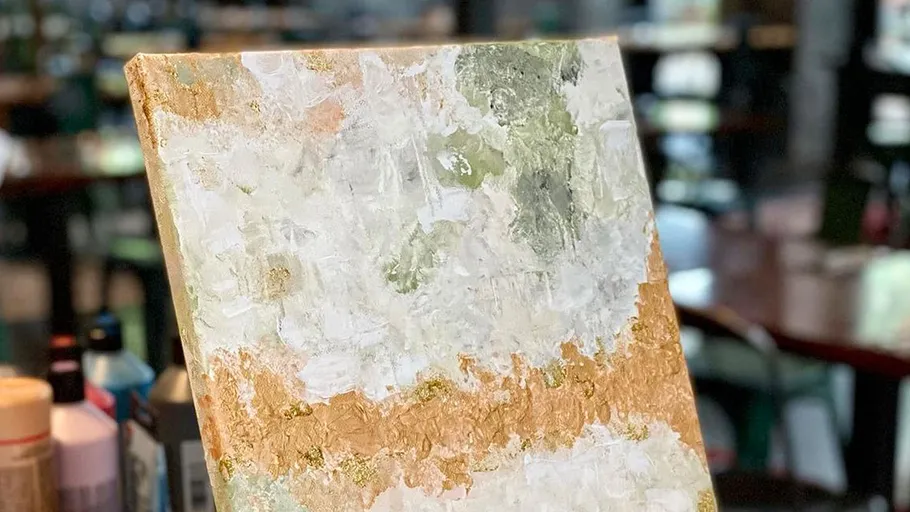 Abstract painting on easel in art studio.