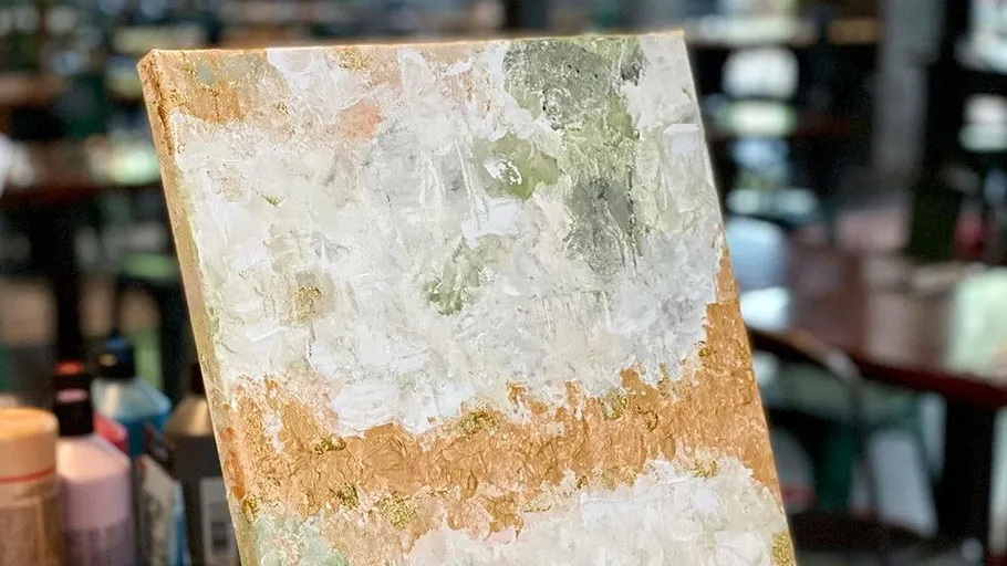 Abstract painting on easel in busy cafe.