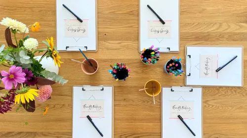 Calligraphy setup with pens on wooden table.