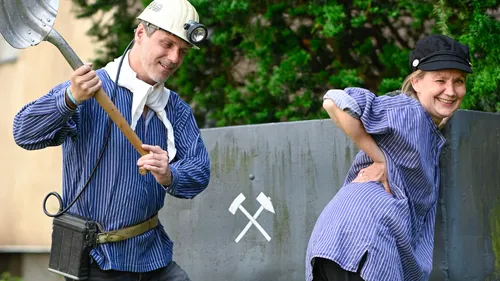Mann mit Schaufel und lächelnde Frau im Garten.