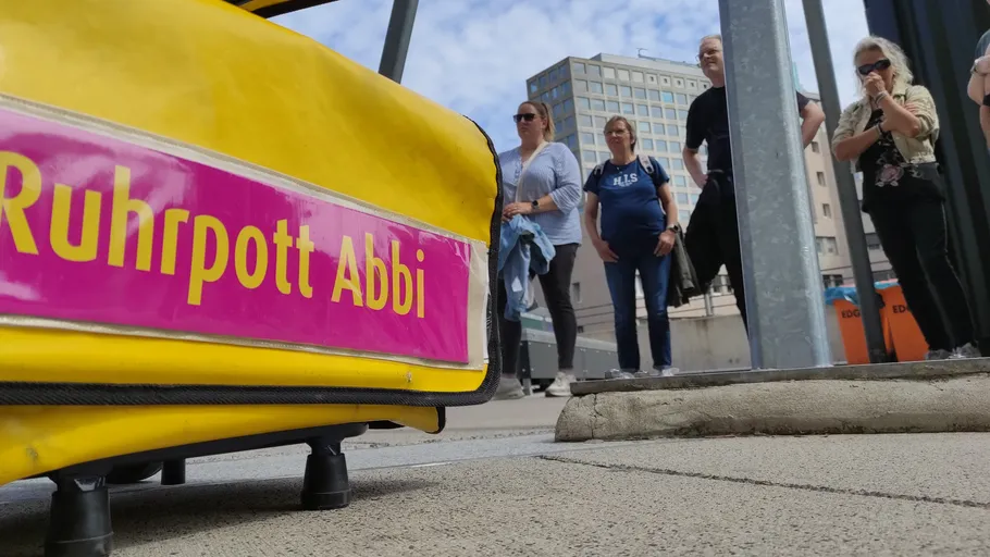 Yellow suitcase labeled 'Ruhrpott Abbi' on ground.