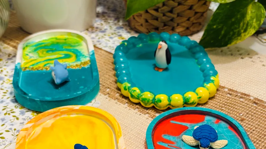 Bunte Harztabletts mit Pinguin-, Hai- und Schildkrötenfiguren.