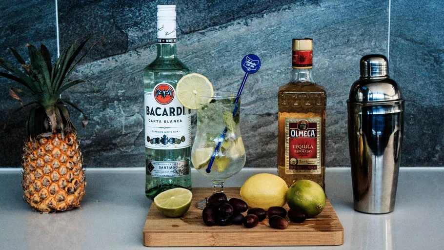 Alkoholflaschen und Früchte auf Küchentheke.