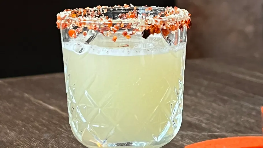 Glass with a spiced rim on dark surface.