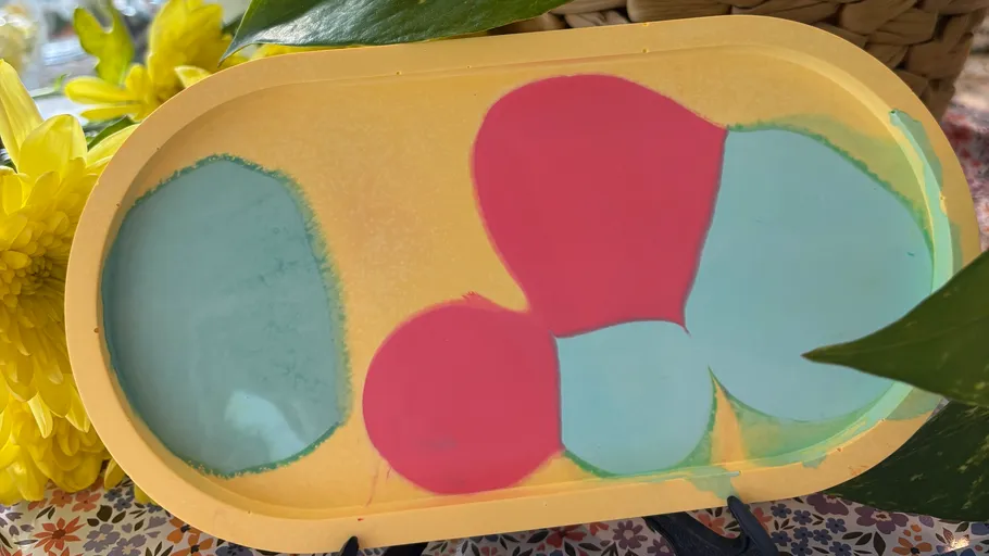 Bunte abstrakte Formen auf gelbem Tablett.