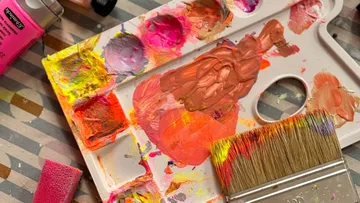 Palette with colorful paints and brush.