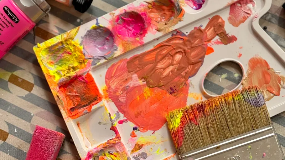 Palette mit bunten Farben und Pinsel.