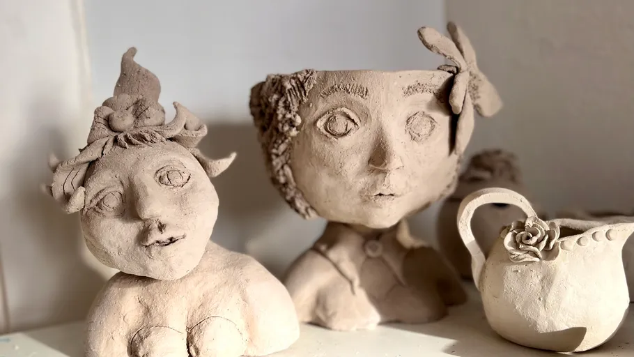 Clay sculptures of whimsical faces and objects.