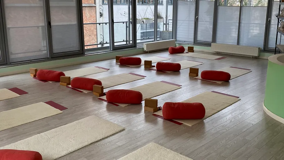 Yoga studio with mats, cushions, and blocks.