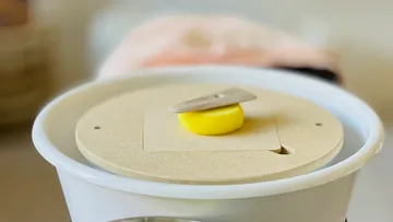 Butter churning tool with indoor background.