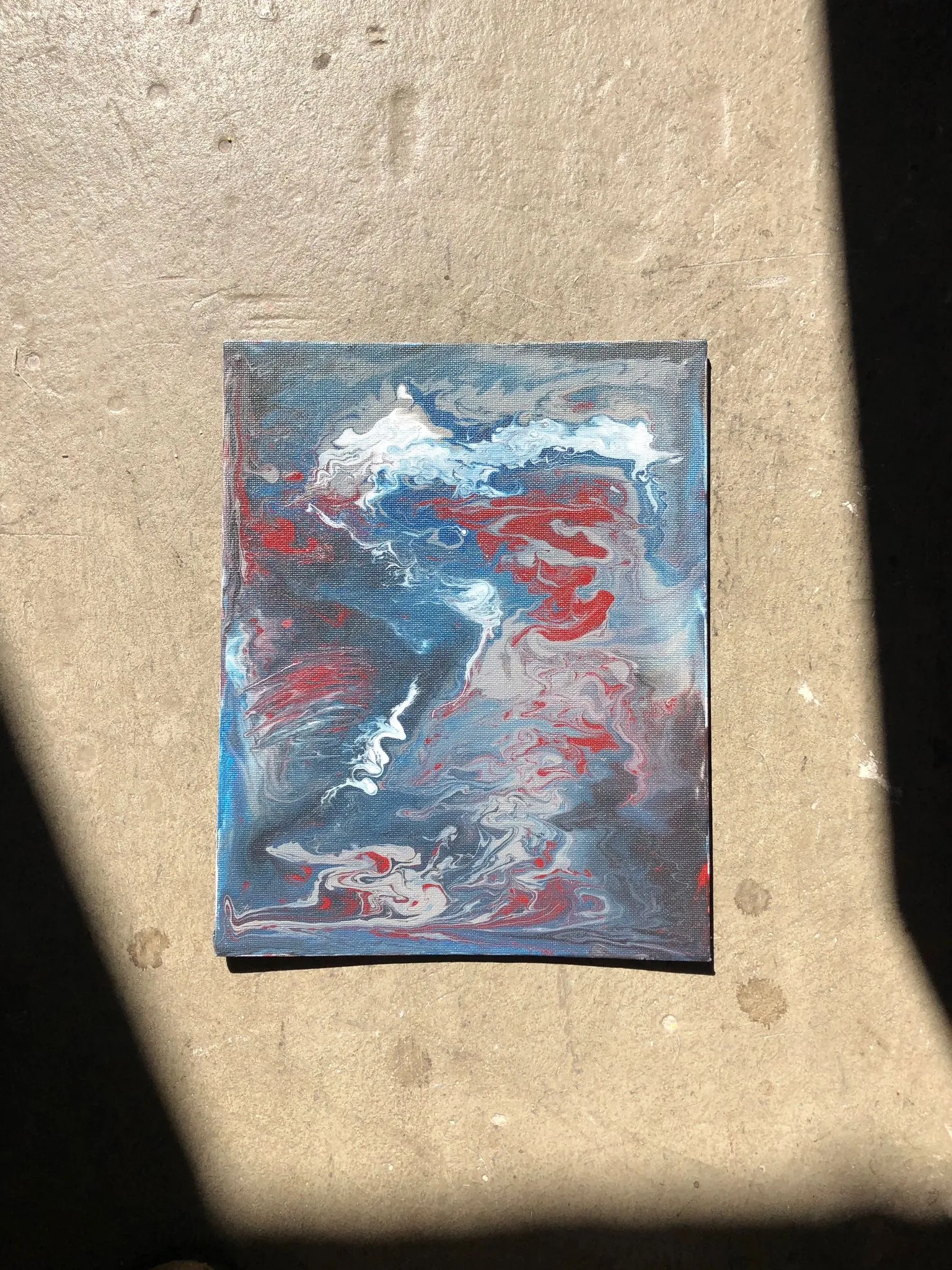 Abstraktes Gemälde mit roten, blauen und weißen Wirbeln.