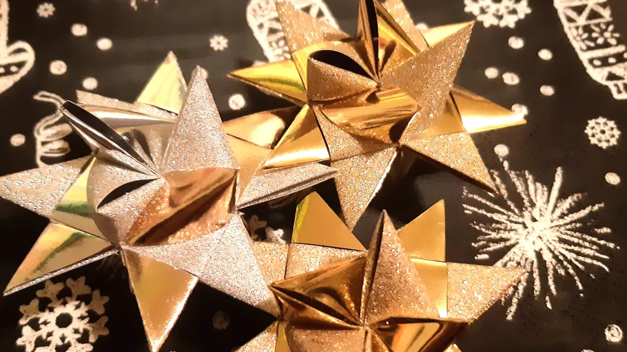 Goldene und silberne Sterne auf Festpapier.