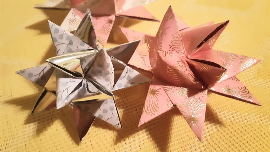Folded paper stars on a yellow surface.