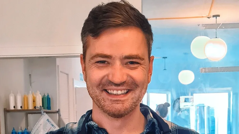 Smiling man in a bright room.
