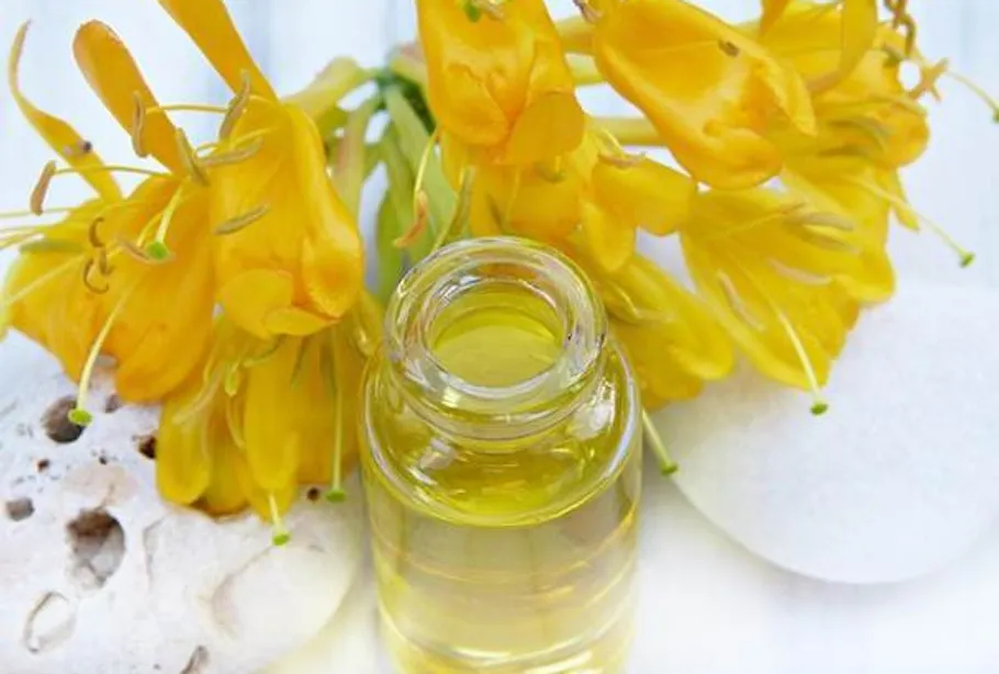 Gelbe Blumen und Flasche mit Öl.