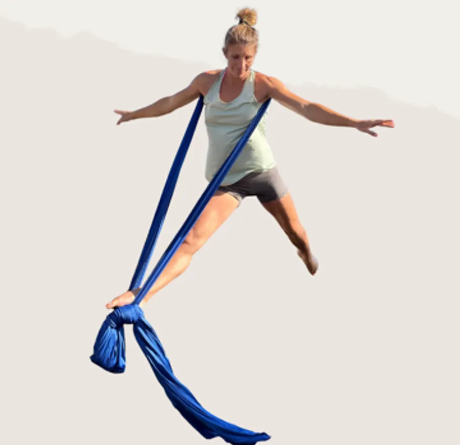 Frau macht Luft-Yoga mit blauem Tuch.