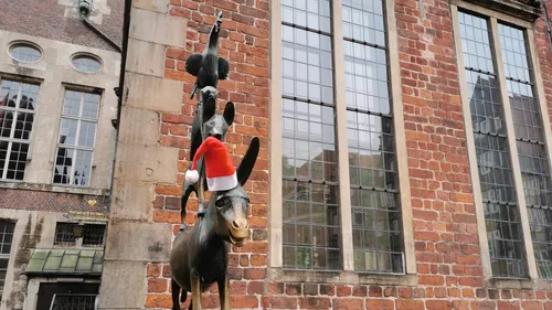 Tierstatue mit Weihnachtsmütze am Backsteingebäude.
