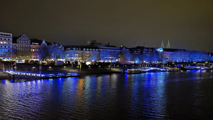 Flussufergebäude mit blauer Beleuchtung.