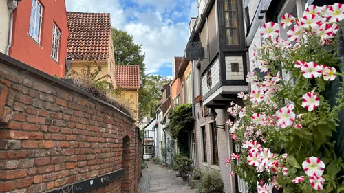 Schmale Kopfsteinpflasterstraße mit bunten Gebäuden.