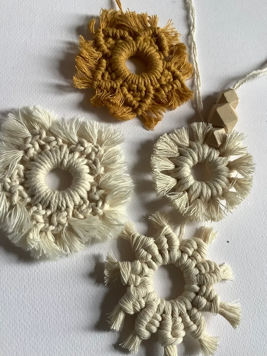 Four macramé ornaments on white background.