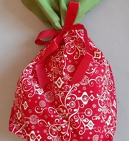 Red gift bag with white patterns and bow.