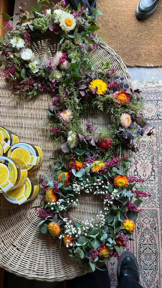 Blumenkränze auf geflochtenem Matten mit gelben Gläsern.